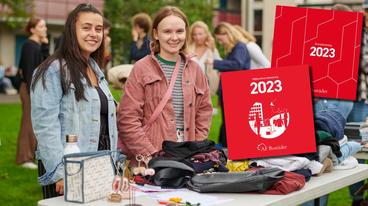 Two students stand behind a table at a flea market. Pictures of the red annual report and sustainability report are in the right in the picture.